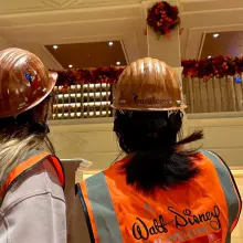 Mitarbeiter von Walt Disney Imagineering schauen auf die Halloween Dekoration an der Brüstung des Disneyland Hotels.