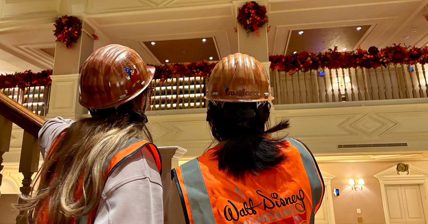 Mitarbeiter von Walt Disney Imagineering schauen auf die Halloween Dekoration an der Brüstung des Disneyland Hotels.