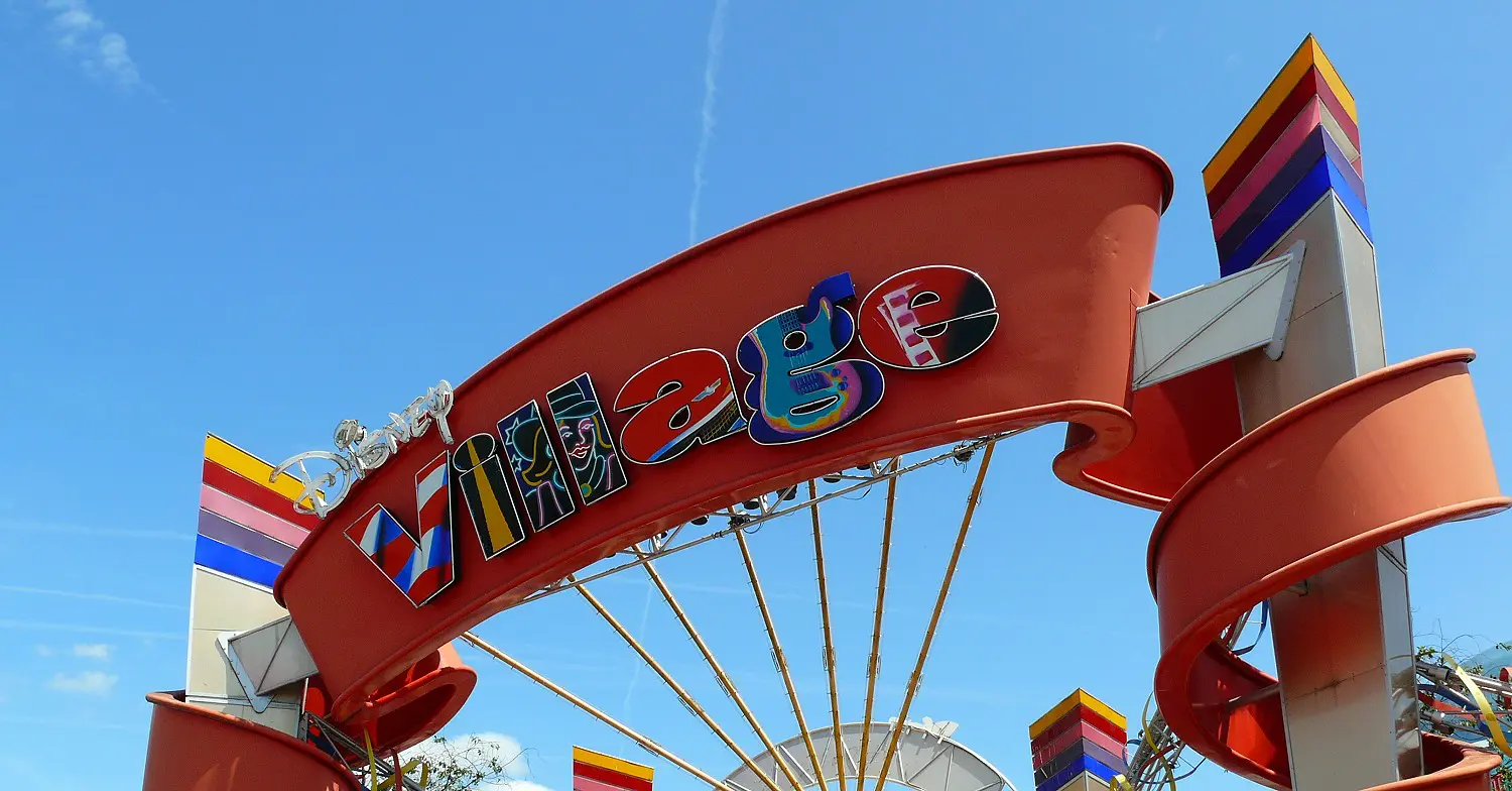 Eingangsschild des Disney Village bei strahlendem Himmel