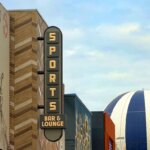 Blick auf die Fassade der Sports Bar & Lounge, im Hintergrund PanoraMagique