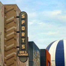 Blick auf die Fassade der Sports Bar & Lounge, im Hintergrund PanoraMagique