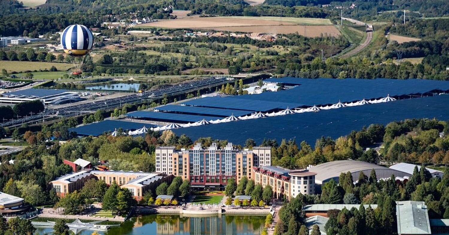 Soalranlage Disneyland Paris Solarpanele auf dem Hauptparkplatz von Disneyland Paris, davor das Disney Hotel New York- The Art of Marvel