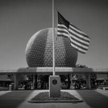 Die US-Flagge auf Halbmast in Epcot am 11.9.2021 - über die Szenerie fallen die Schatten der Türme des World Trade Centers