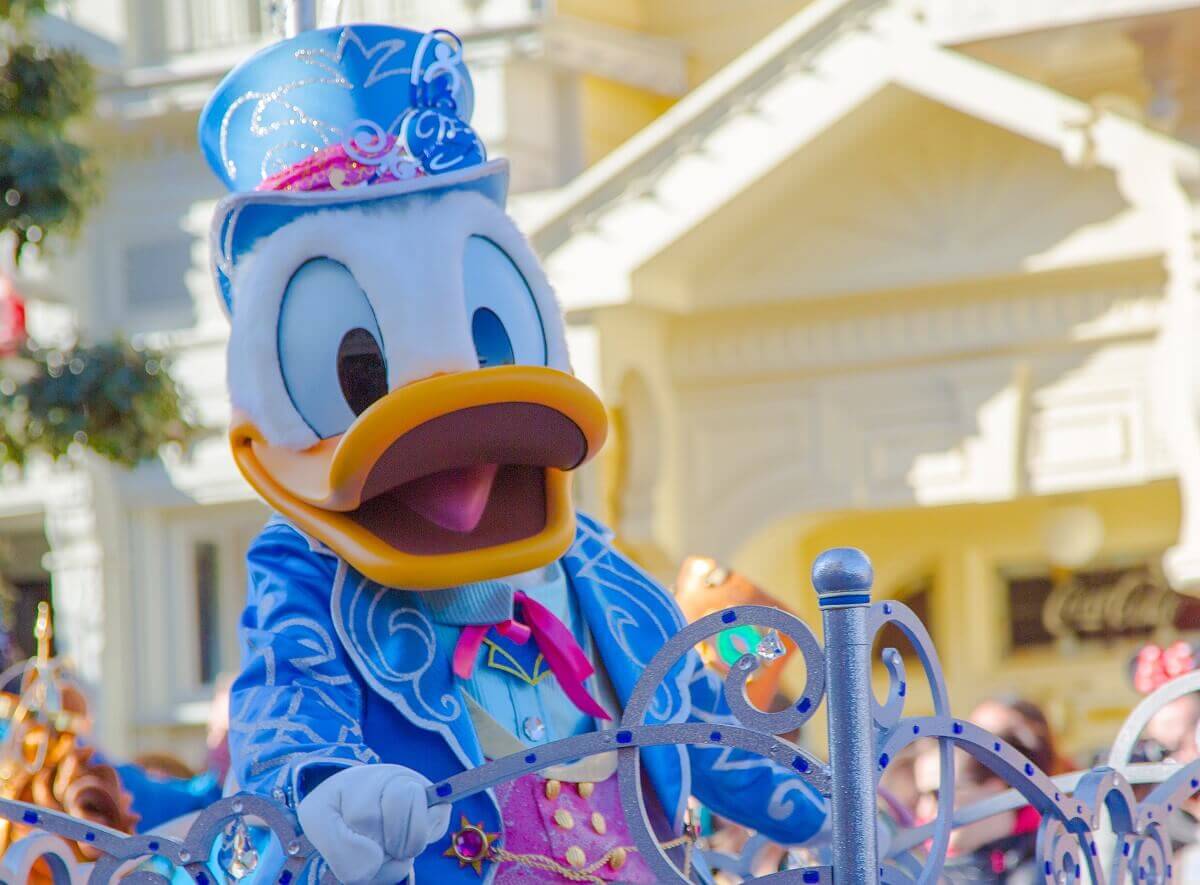 Donald Duck in einem hellblauen Anzug und Zylinder mit silberfarbenen Applikationen, speziell für den 25. Geburtstag von Disneyland Paris