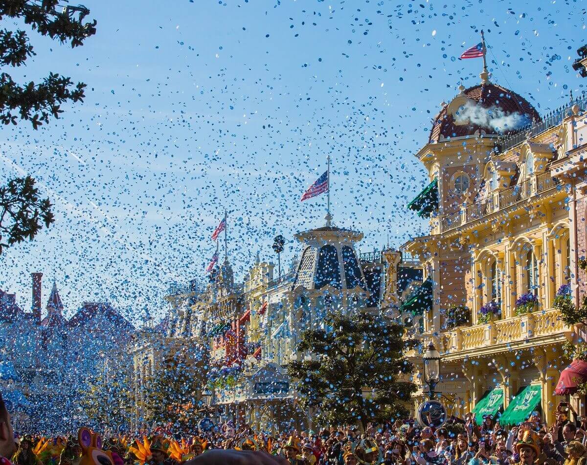 Blick über die Main Street, U.S.A. in Disneyland Paris, auf der es gerade bei strahlend blauem Himmel einen Konfettiregen gibt
