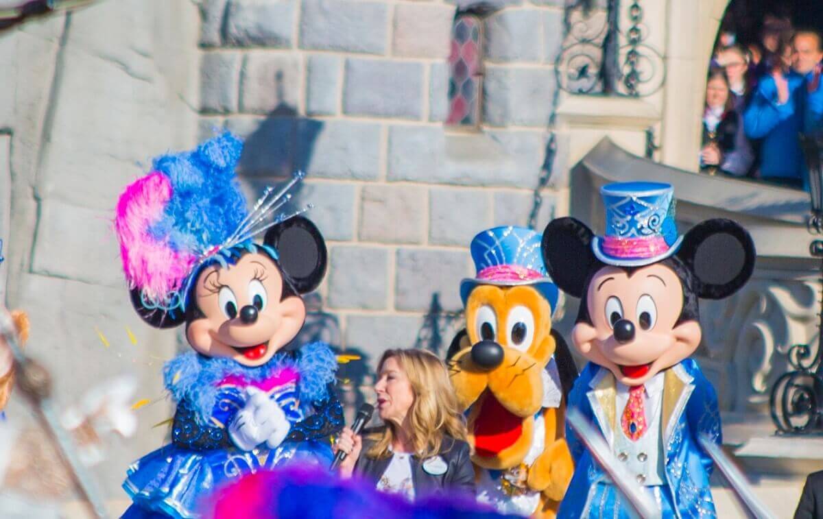 Catherine Powell hält eine Rede zum 25. Jubiläum von Disneyland Paris, Mickey, Minnie und Pluto stehen dabei hinter ihr