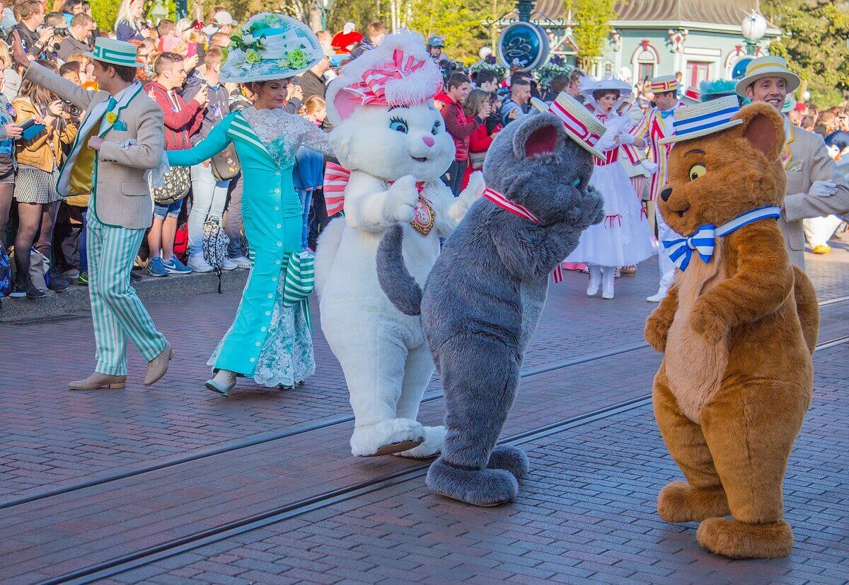 Die drei Aristocats Marie, Toulouse und Berlioz auf der Main Street, U.S.A. ihnen folgen Tänzer und Marry Poppins mit Bert 