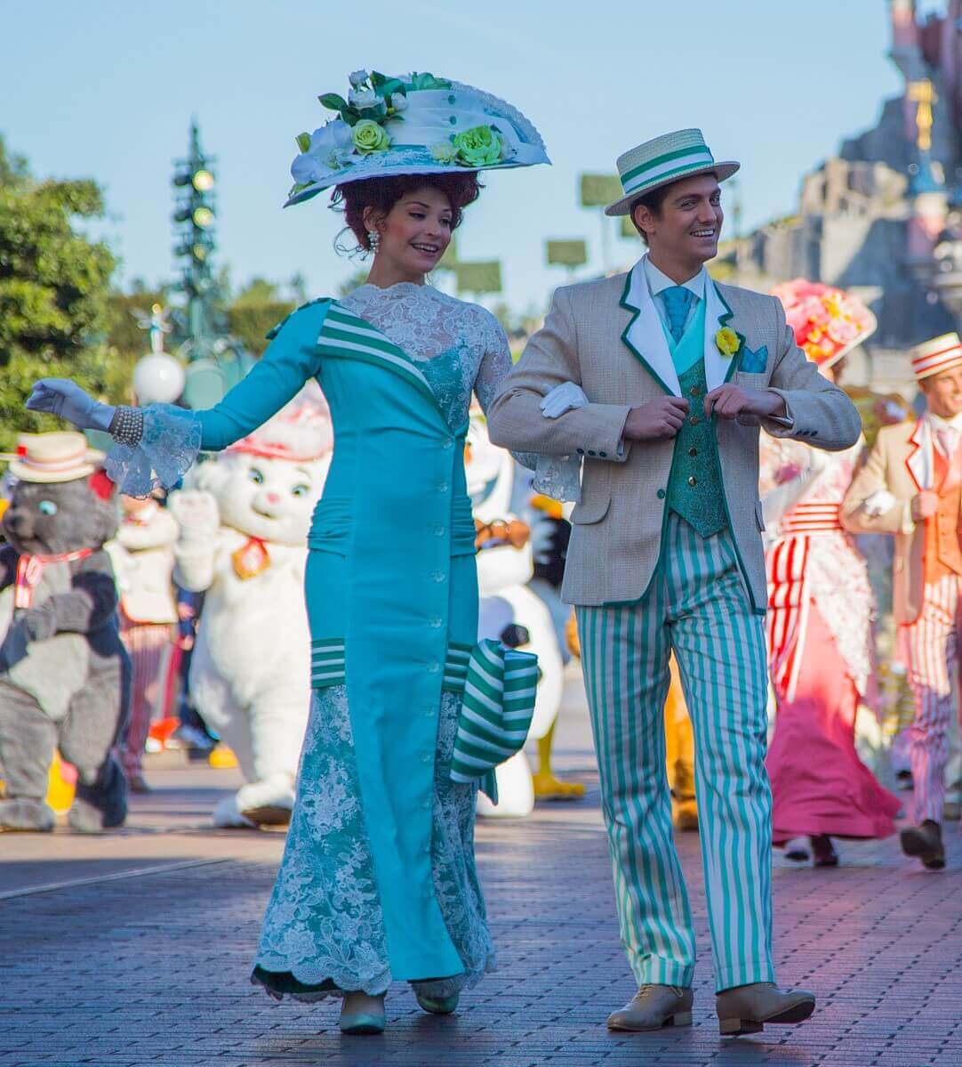 Ein Tanzpaar in grün-beigefarbenem Kostüm bei der Geburtstagsshow von Disneyland Paris auf der Main Street, U.S.A.