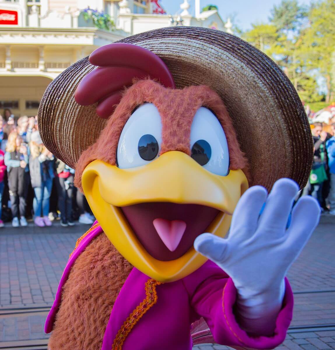 Der Hahn Panchito Pistoles winkt in die Kamera - er marschiert bei der Geburtstagsshow über die Main Street, U.S.A.