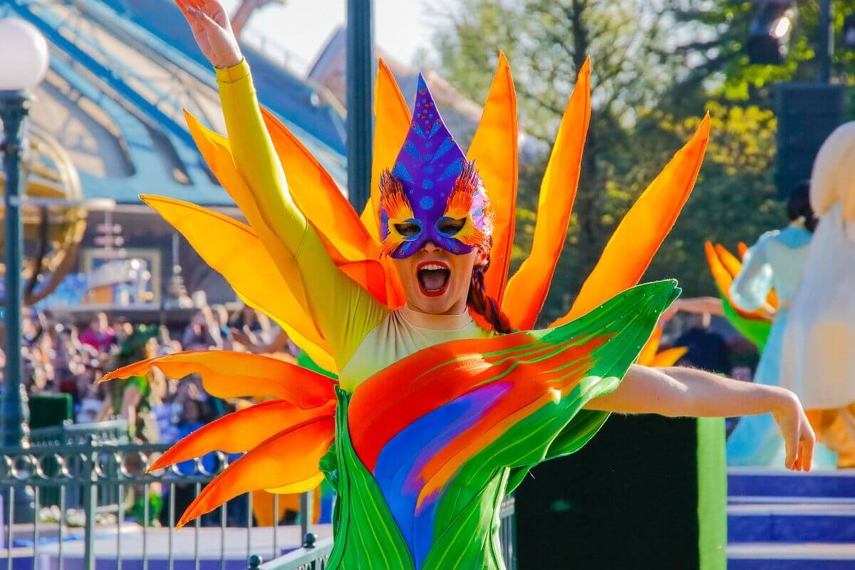 Eine Tänzerin in Disneyland Paris trägt ein Kostüm, das an eine bunte Blume erinnert
