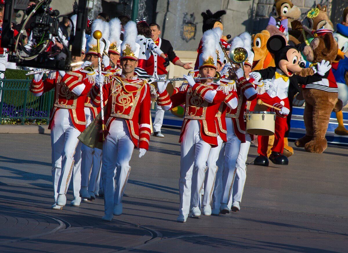 Eine in weiß-roten Uniformen gekleidete Marchingband bildet den Auftakt zur Geburtstagsparade von Disneyland Paris