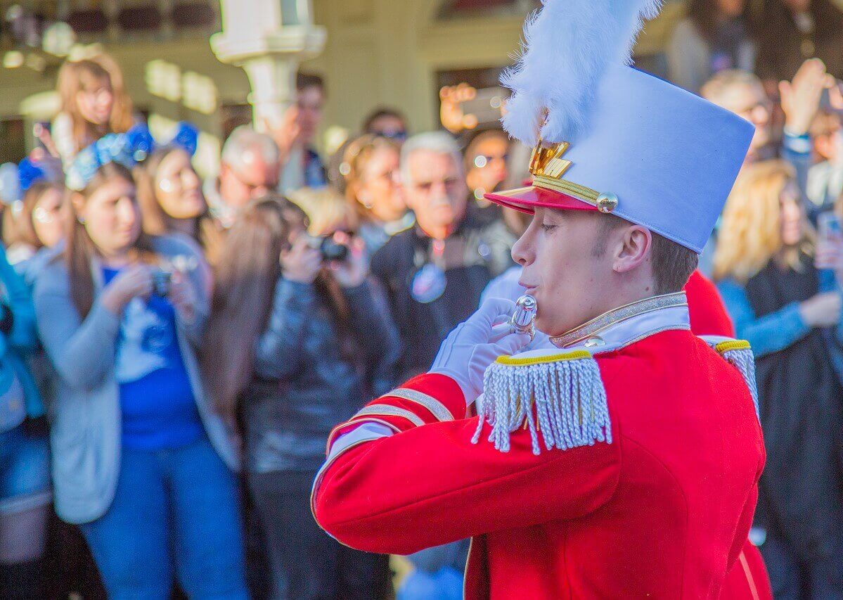 Ein Querflötist der Marchingband bei der Parade am 12. April 2017. Er ist von der Seite aufgenommen und trägt ein rotes Jacket sowie einen weißen Hut