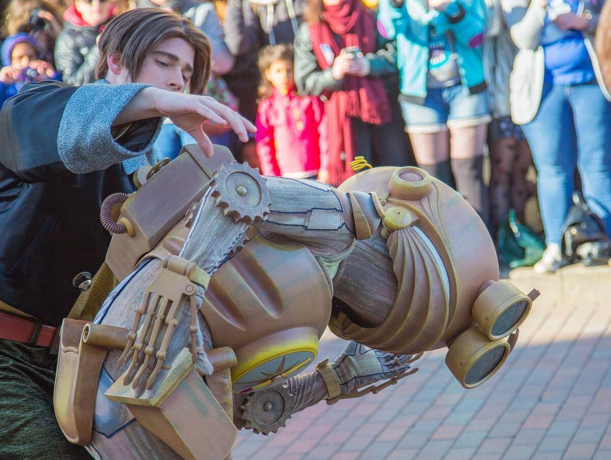 Jim Hawkins beugt sich über den nach vornegebeugt laufenden Roboter B.E.N.