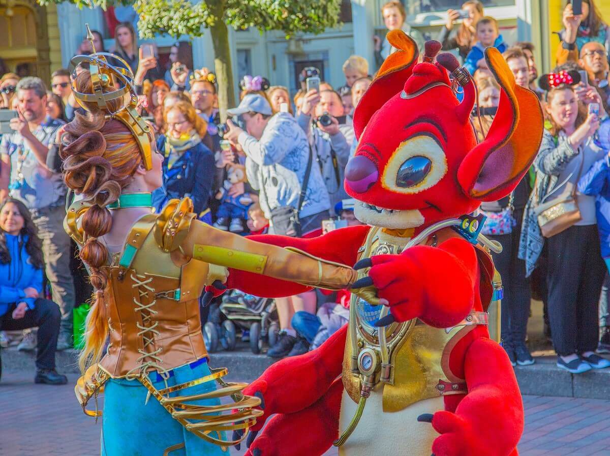 Das rote Alien Leroy tanzt mit einer Tänzerin in einem Steampunkoutfit gemeinsam über die Main Street, U.S.A.