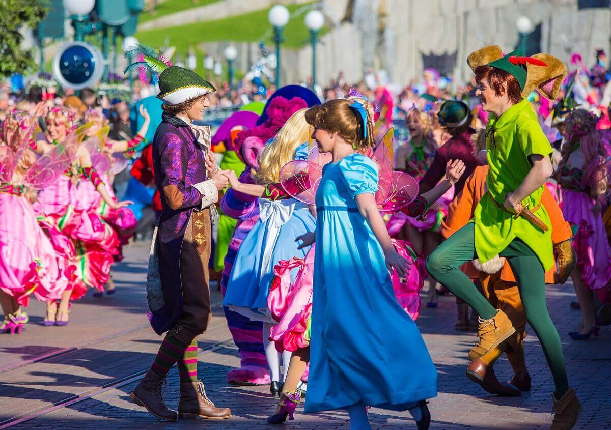 Wendy und Peter Pan tanzen bei der Geburtstagsshow von Disneyland Paris begleitet von zahlreichen Tänzern in märchenhaften Kostümen