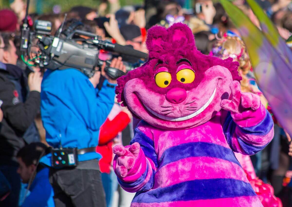 Die Grinsekatze und neben ihr Alice im Wunderland mit einem breiten Lächeln im Gesicht