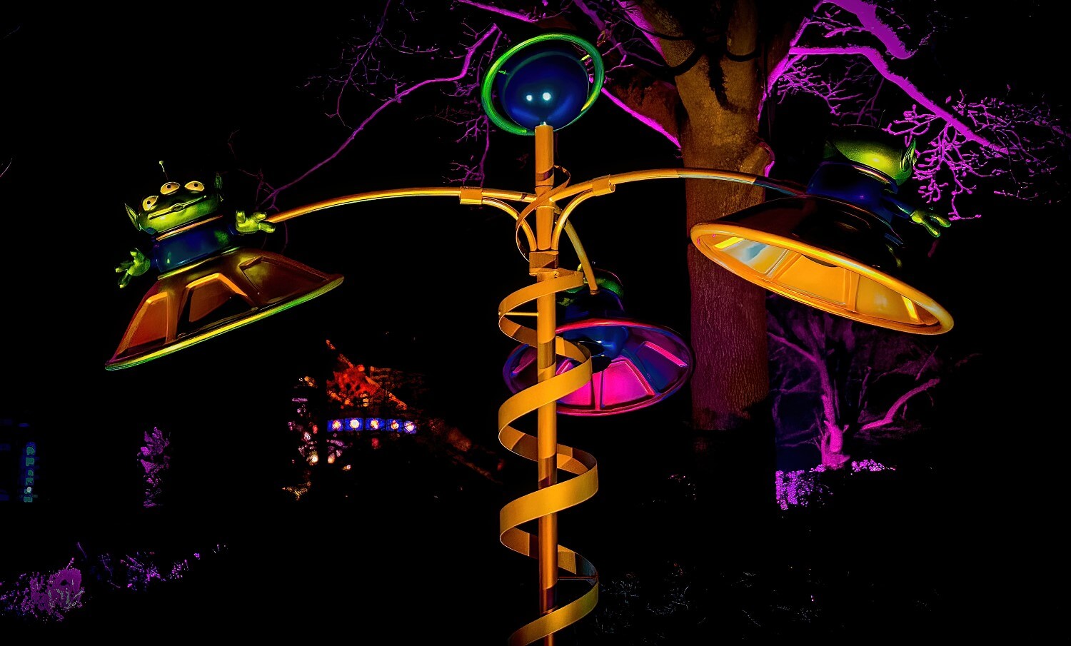 Nachtaufnahme der Toy Story Skulptur in den Gardens of Wonder, die drei grüne Aliens in fliegenden Untertassen zeigt
