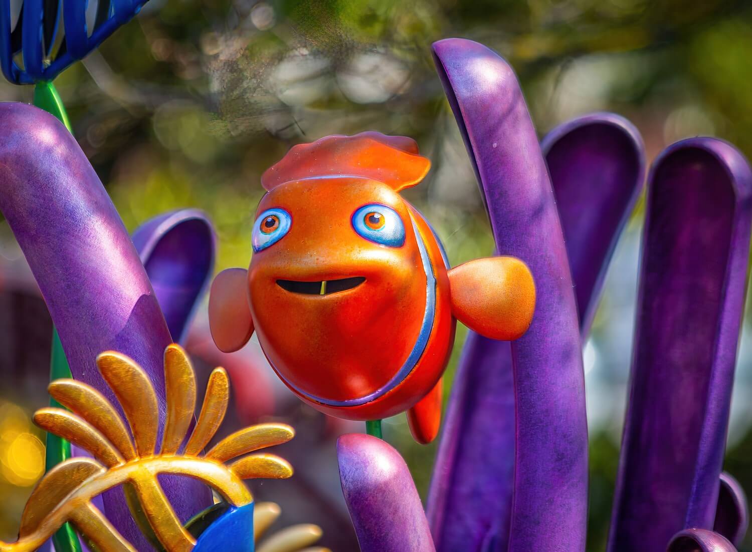 Skulptur des Clownsfisch Marlin, der aus einer Wasserpflanze hervorschwimmt