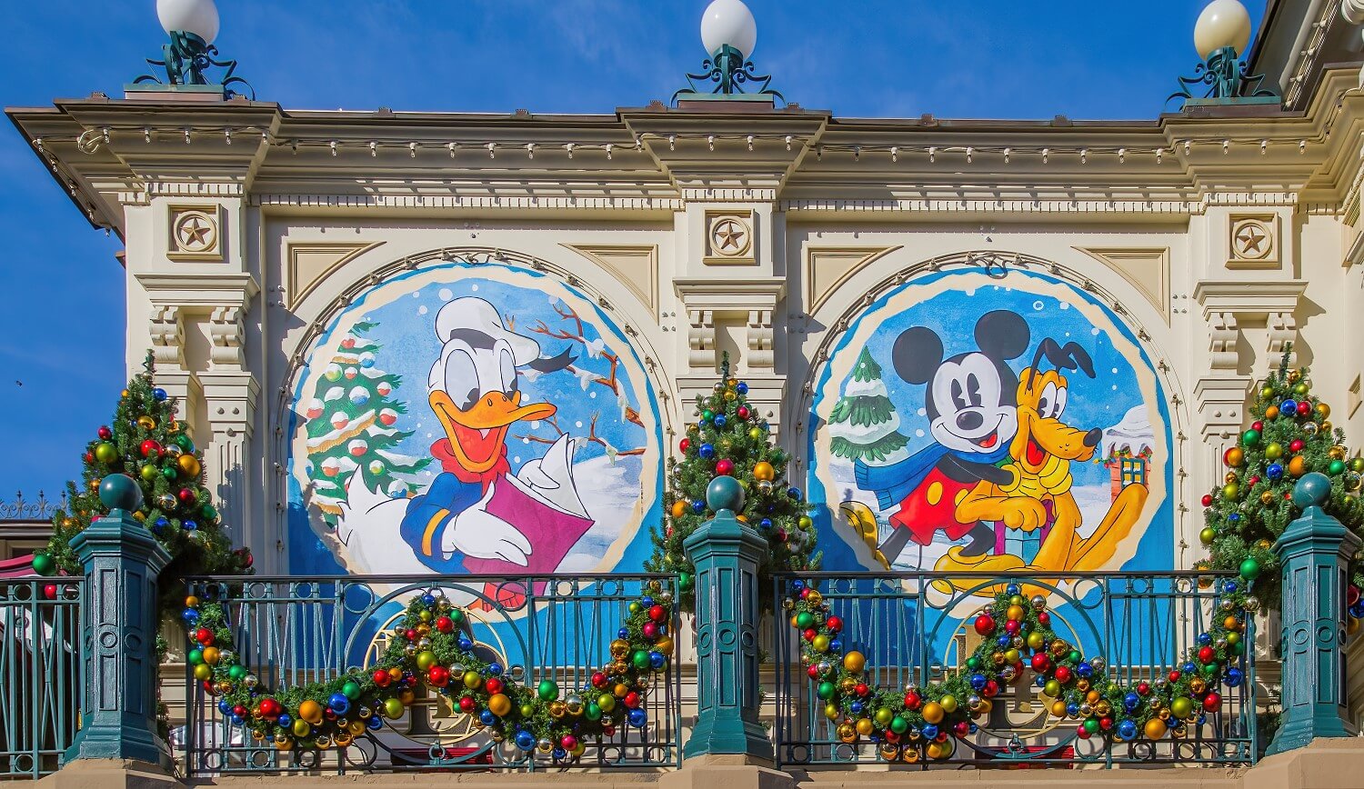 Tafeln vor den Fenstern des Bahnhofs, die weihnachtliche Motive mit Donald Duck, Mickey Mouse & Pluto zeigen