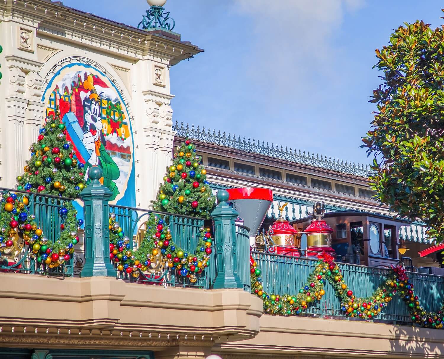 Ein Zug der Disneyland Railroad fährt in den weihnachtlich geschmückten Bahnhof der Main Street U.S.A. ein