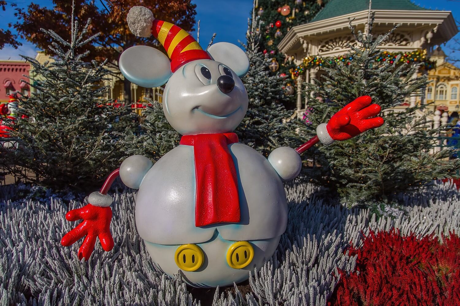 Mickey Mouse Schneemann mit roten Handschuhen, rotem Schal und rot-gelb gestreifter Pudelmütze