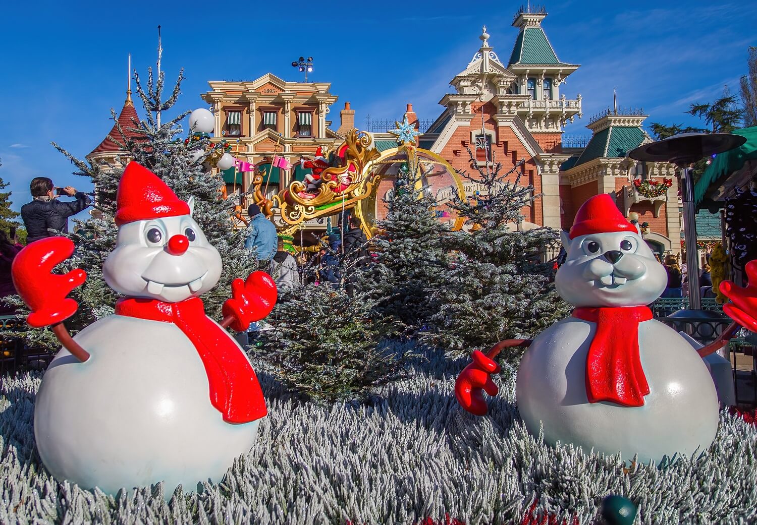 Chip & Dale als Schneemänner am Town Square, im Hintergrund fährt gerade der Paradewagen mit dem Schlitten des Weihnachtsmannes vorbei
