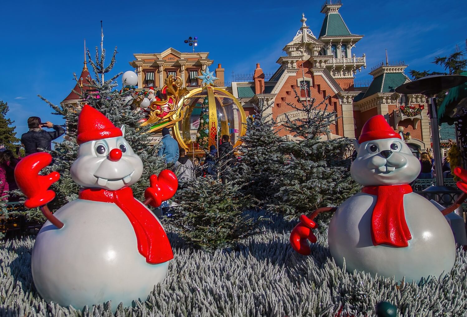Chip & Dale als Schneemänner am Town Square, im Hintergrund der vom Schlitten winkende Santa Claus und das Depot der Main Street Transportation Company