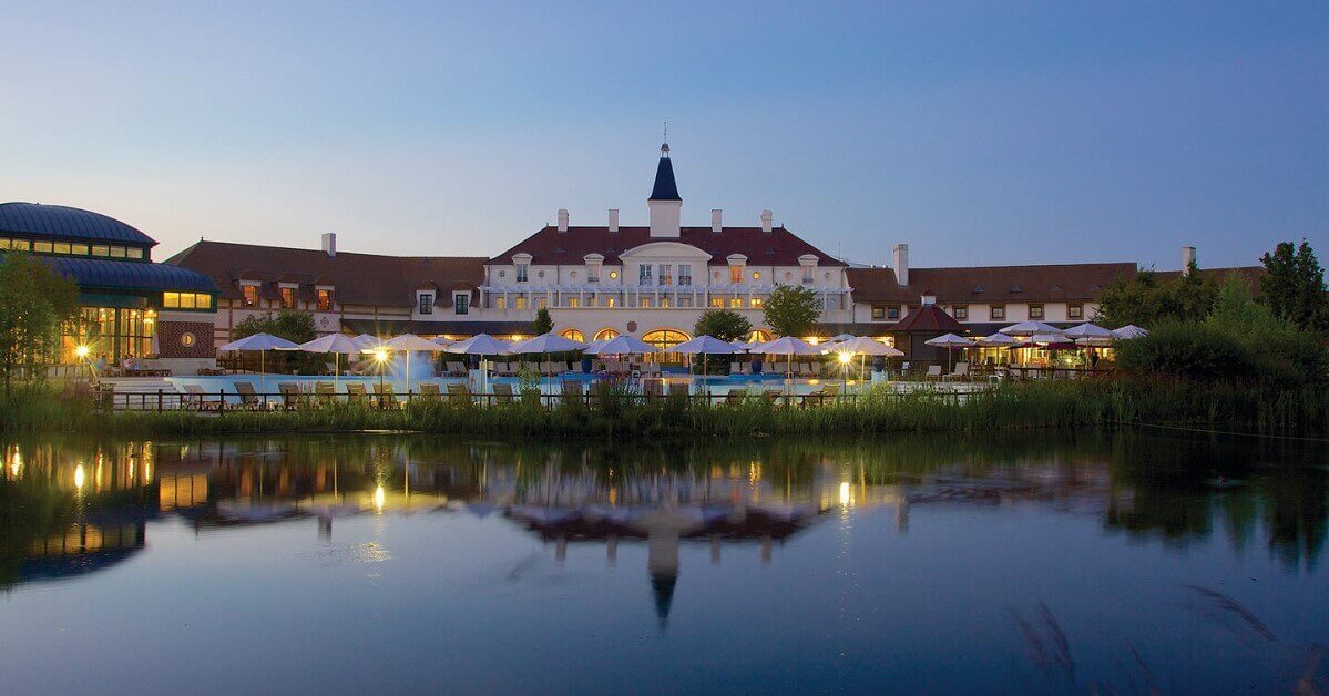 Das Haupthaus des Marriott Village bei Nacht über den See gesehen