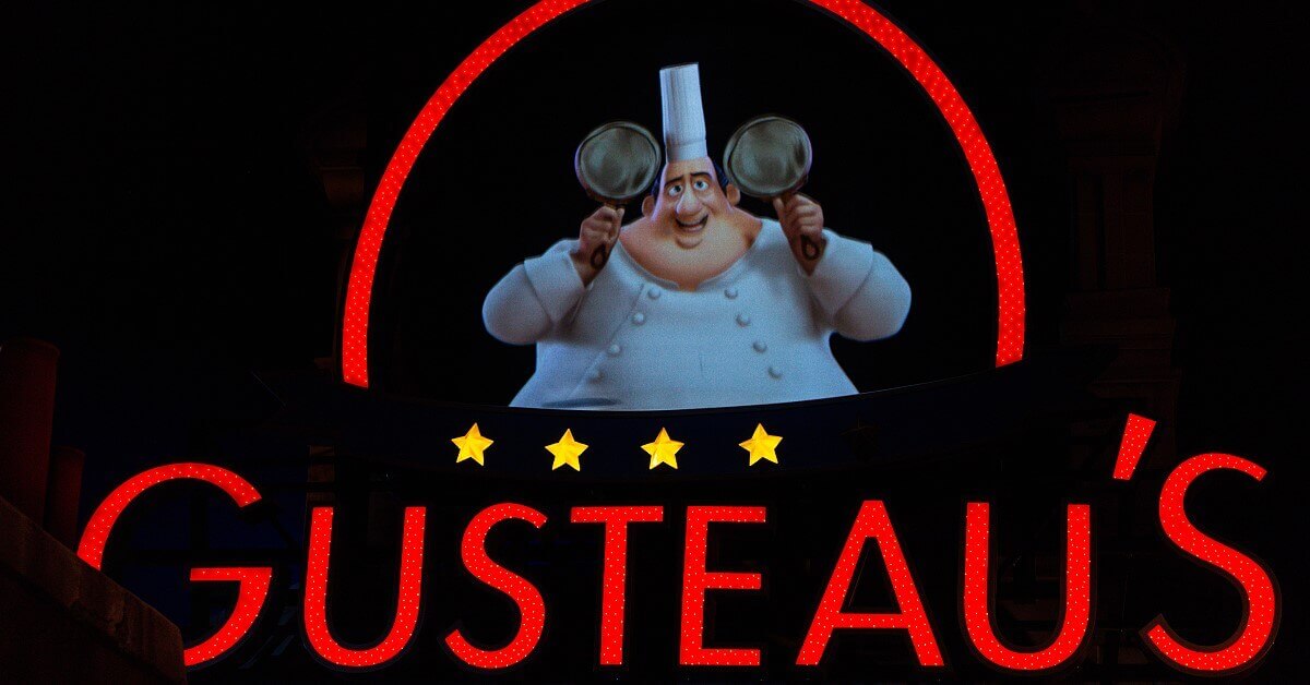 Werbetafel mit Gusteau, der mit Pfannen Mickey-Ohren formt, im Wartebereich von Ratatouile - the Adventure