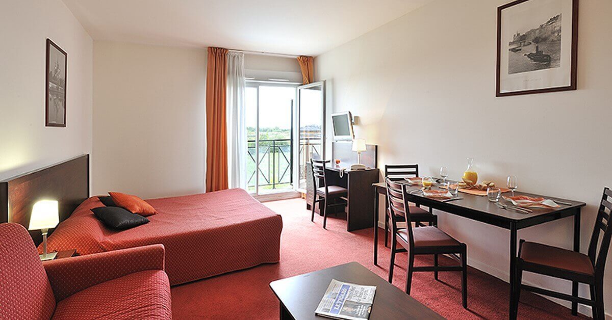 Ein Zimmer im Hotel Residence du Parc mit Mobiliar in Rot- und Brauntönen