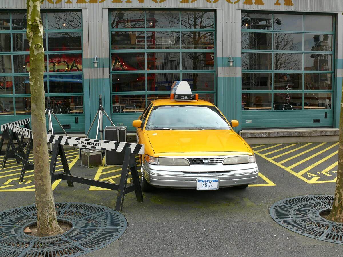 A taxi in front of the former counter service restaurant Blockbuster Café