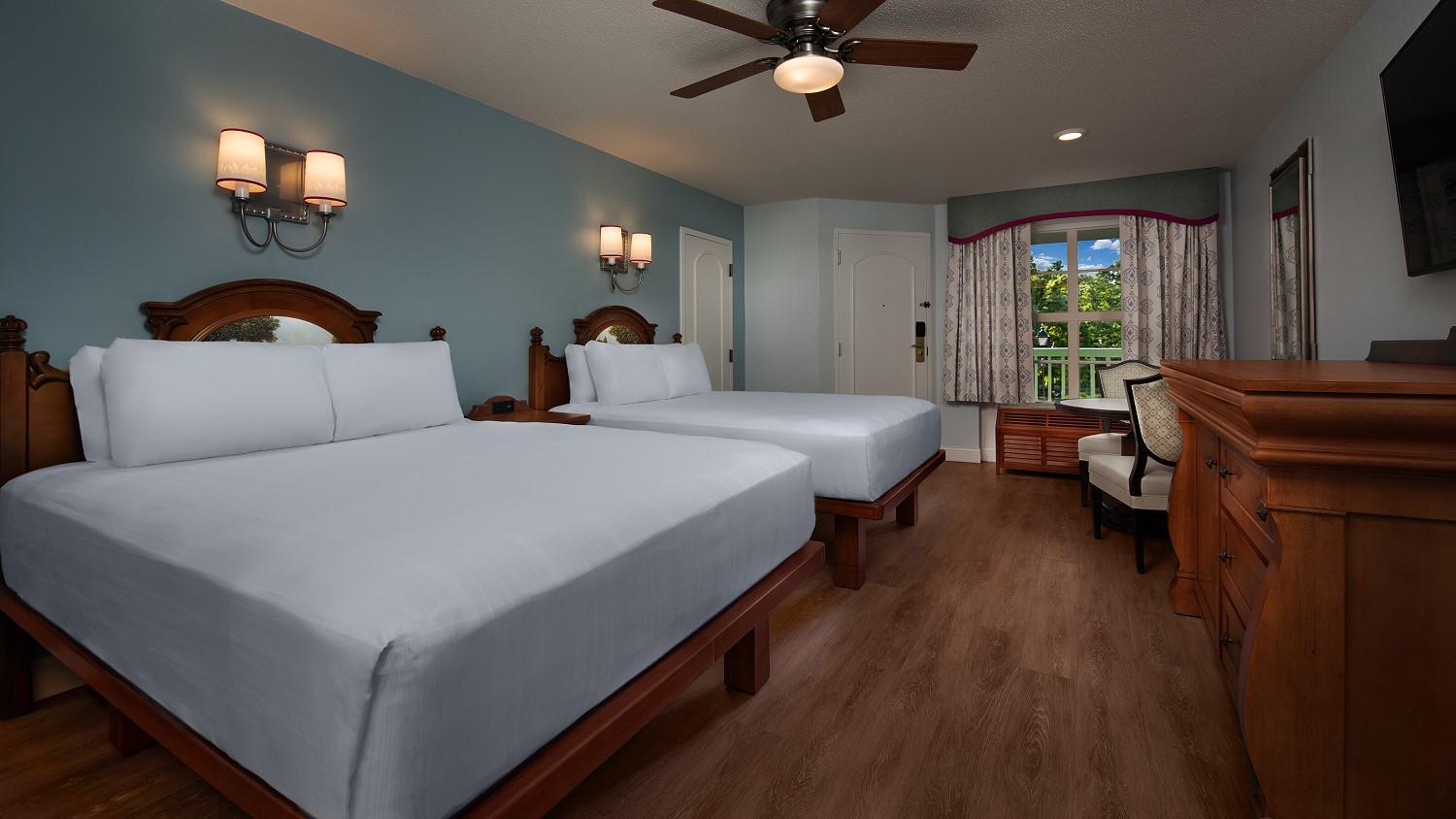 Hotelzimmer im Port Orleans Riverside Resort mit zwei Queensize Betten, Kommode sowie Tisch mit Stühlen